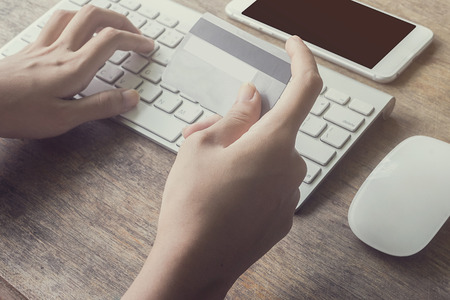 woman using computer to online shopping and pay by credit card, Low light, selective focus on hand, can be used for e-commerce, business, technology and internet concept, Vintage toneの写真素材