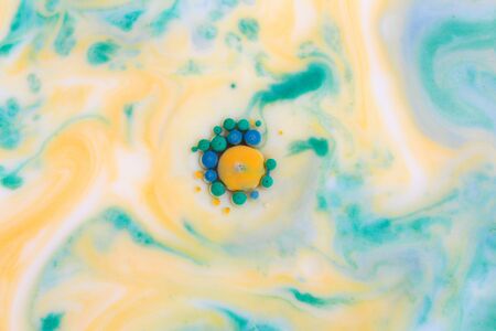 Abstract background, green and yellow color mix together in milk. Macro photoの写真素材