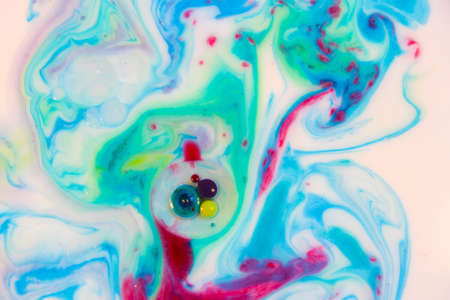Abstract background, blue, green and red color mix together in milk with small color dots. Macro photoの写真素材