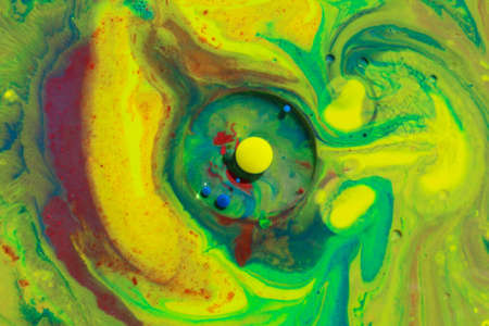 Mixing abstract colors in milk with yellow, green and blue colorsの写真素材