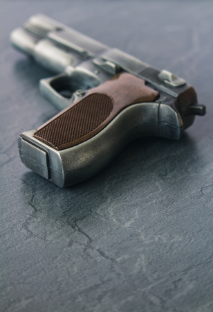 Handgun pistol on dark marble background from backの写真素材