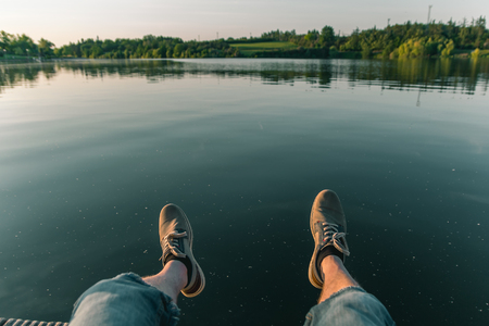 Man leg on pond Jordan at sunset in city Tabor, Czech republicの写真素材