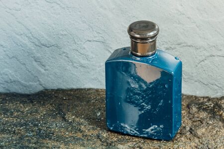Blue aftershave bottle on wet stone textureの写真素材