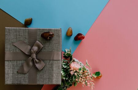 Flower bouquet with gift box and stone on colorful background from top. Can be used for wedding, mothers day, valentineの写真素材