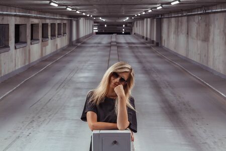 Portrait of beauty young blonde hair woman standing in garageの写真素材
