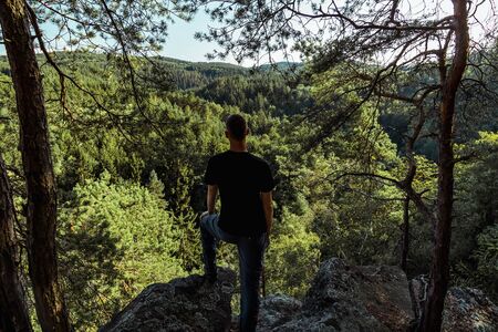 Young man standing and looking to nice summer valley, Czech republicの写真素材