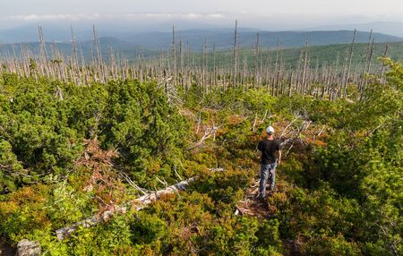Aerial view on young man tourist in white cap, Sumava National Park and Bavarian Forest, Czech...