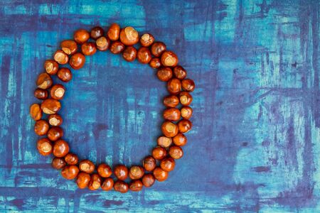 Chestnut circle frame on blue board, autumn backgroundの写真素材