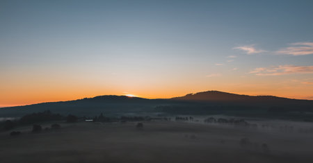 Nice autumn sunrise with misty fog on meadow and hill, Czech landscape, toned photo