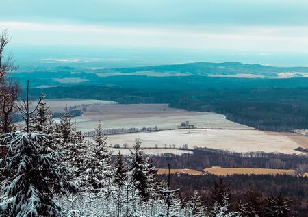 Nice view to snow covered field with distant hill and sky. Novohradske mountain, Czech republicの写真素材