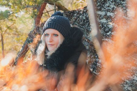 Portrait of beauty young blonde hair woman in winter hat, jacket on stone background.の写真素材