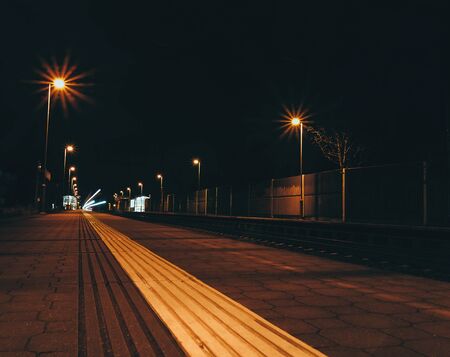 Light colorful train trails at night. Train stop in station. Traffic, travel long exposure photo