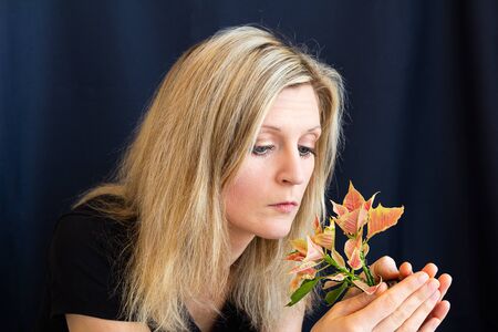 Portrait of beauty young blond hair woman holding flower euphorbiaceae