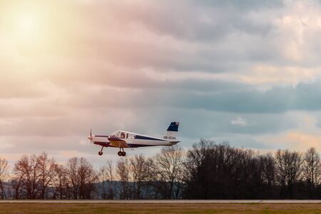 Ultralight plane take off from runway on airports with cloud sky and sun.の写真素材