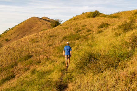 Young man walking on hill Rana in Czech central mountain landscape