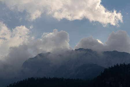 Misty fog after rain on Austia Alps mountain with blue sky