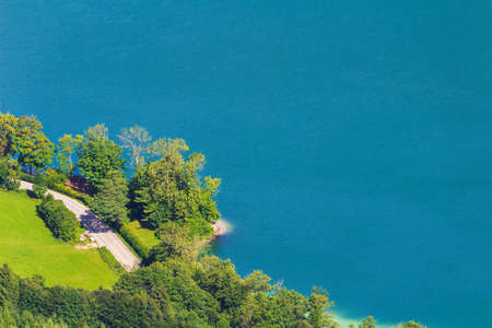 Aerial view to lake attersee peninsula shore edge with trees and beach. Austria, salzburgの写真素材