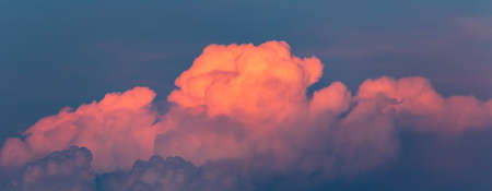 Panoramic view to pink sunset cumulus cloud on blue summer sky. Nature background