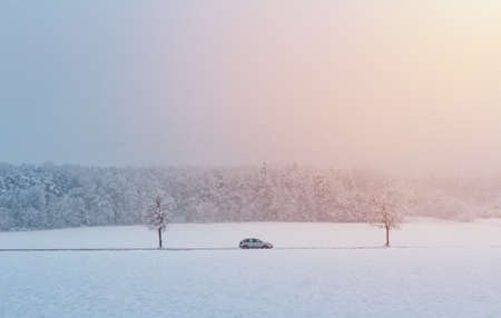 Car ride on road in winter Czech landscape with snow and sun. Transportation in bad weatherの写真素材