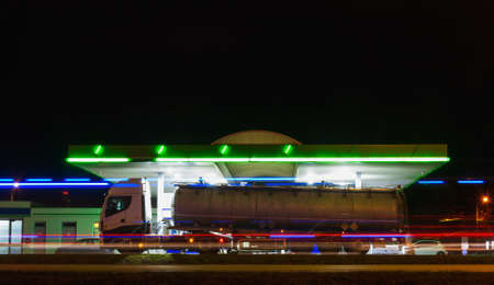 Truck refuel on gas station with motion traffic in city at night. Long exposure of car light, Czech republicの写真素材
