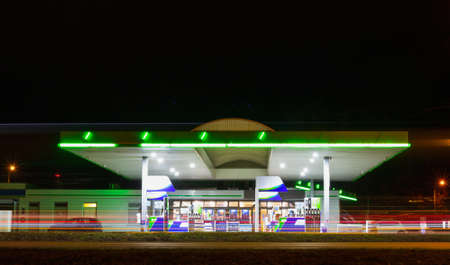 Gas station with motion traffic in city at night. Long exposure of car light, Czech republicの写真素材