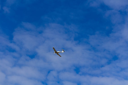 Small ultra light plane fly against blue sky with clouds. Extreme sport, travel background with copy spaceの写真素材