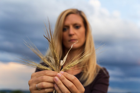Portrait young Caucasian woman holding corn, grain. Agriculture concept
