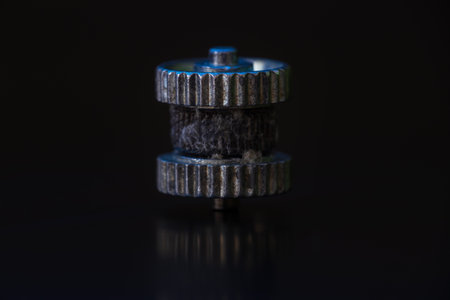 Close up small used steel wheel from firestarter on black backgroundの写真素材