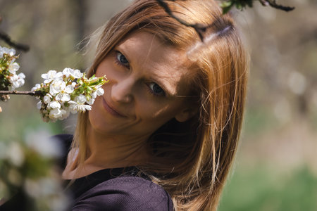 Portrait of young beauty Caucasian woman in cherry blossom tree. People, spring conceptの写真素材