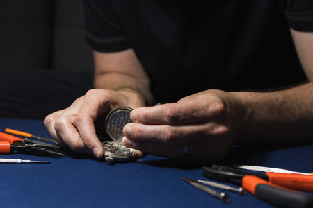 Man, watchmaker hand repair pocket watch with tweezers. Craft, hand made work background