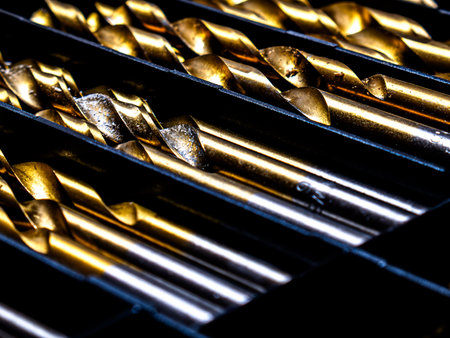 Metal drill bits with coating neatly arranged in a storage box. The image highlights precision tools, industrial equipment, craftsmanship, and organization for professional or DIYの写真素材