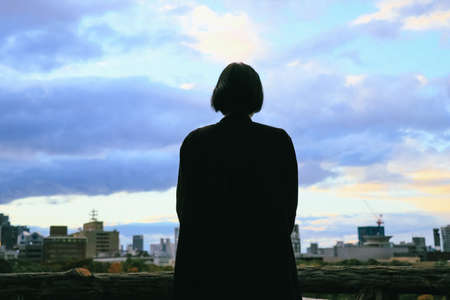 Short-haired woman looking out at city and skyの写真素材