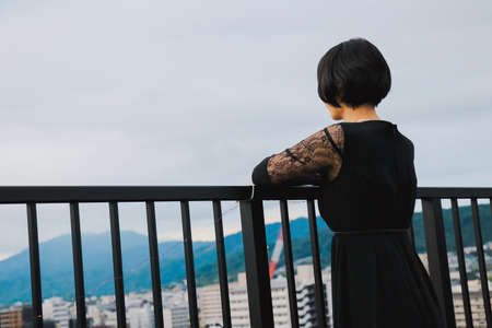 Short-haired female model looks out at the city from rooftop