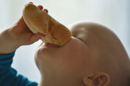 Baby holding a loaf of bread