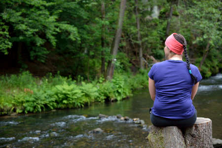 Woman relaxing by the riverの写真素材