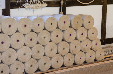 A large stack of wood spindles on Which there are hemp cords.の写真素材