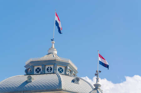 Gable view with flags of the Kurhaus in Scheveningen Netherlands, Holland against a blue sky.の写真素材