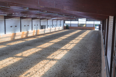 View in an indoor riding arena. The riding school is suitable for dressage horses.の写真素材