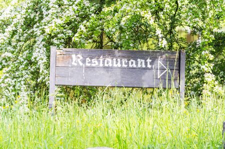 Information Sign of weathered wood with inscription Restaurant. In the background of green trees.の写真素材