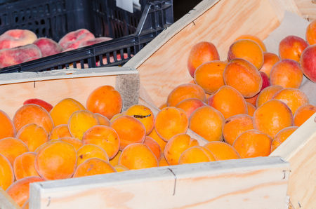 Fresh peaches in a wooden box for sale at a farmers market.の写真素材