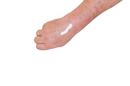 Man's arm with a white cream against white background.の写真素材