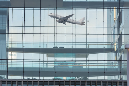 Modern office building with glass facade in the background a plane when you start.の写真素材