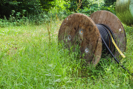 Cable drum, large industrial cable reel with a black fiberglass cable.の写真素材