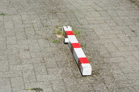 On the road lying red and white striped bollards to close off the passage.の写真素材