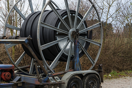 Steel roller with fiber optic cables for the installation of data cables on a construction site.の写真素材