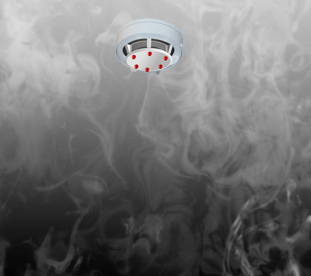 Smoke detector on the ceiling with red warning light sensor and smoke.の写真素材