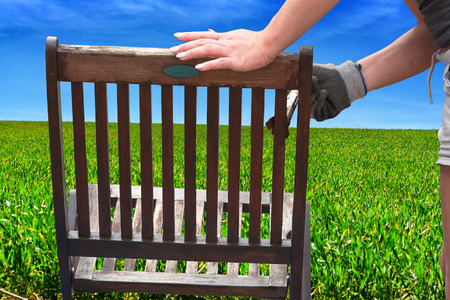 Painting and applying protective eco-friendly paint on a wooden garden chair.の写真素材