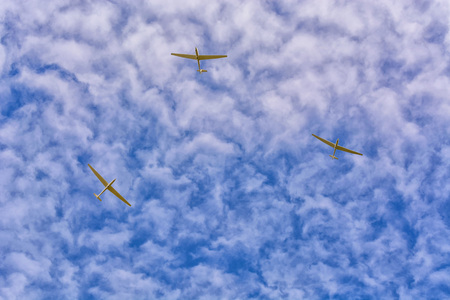 3 gliders in the blue sky. Motorless flying with a glider by using the thermal.