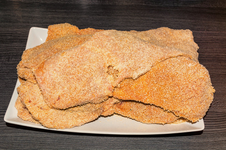 Freshly baked raw escalope of veal on a white plate.の写真素材