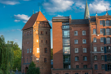 View of a hotel in the German city of Lüneburg. Beautiful cityscape with reflections of houses on water and sky with clouds.のeditorial素材